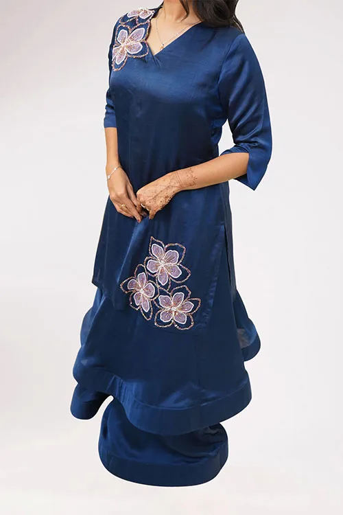 A closer view of the Almond Blossom Lehenga, three lilac blossoms outlined in beadwork sitting across the front of the navy tunic